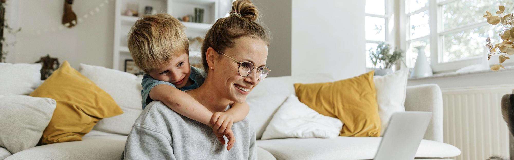 Mother and child using a laptop together in their living room